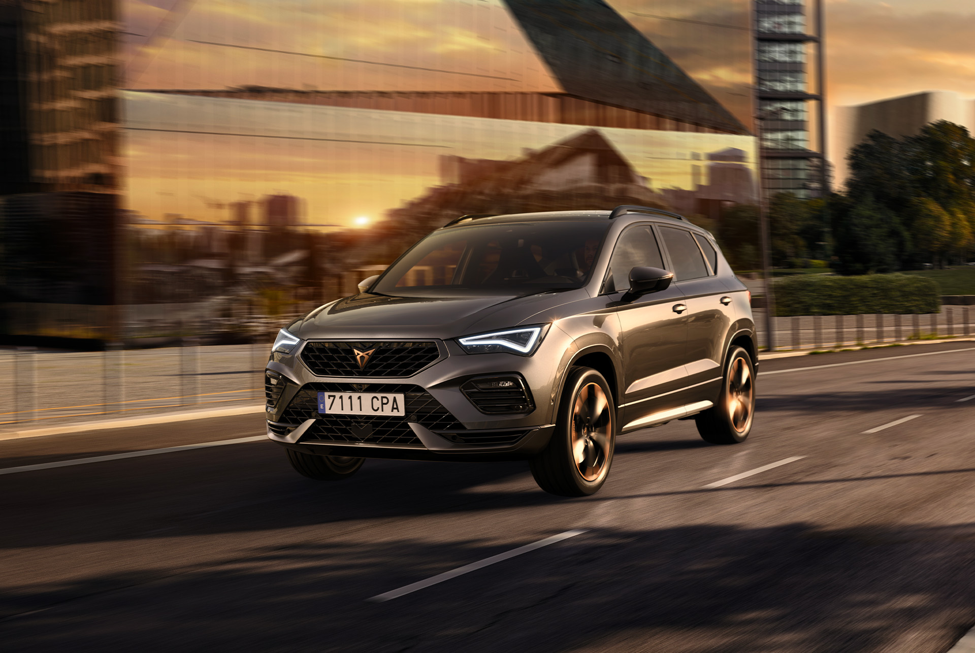 CUPRA Ateca SUV pilsētas ielās saulrietā. Šis SUV ir pieejams ar 150 un 190 ZS dzinējiem un pilnpiedziņu, zemākiem izmešiem un mazāku degvielas patēriņu.