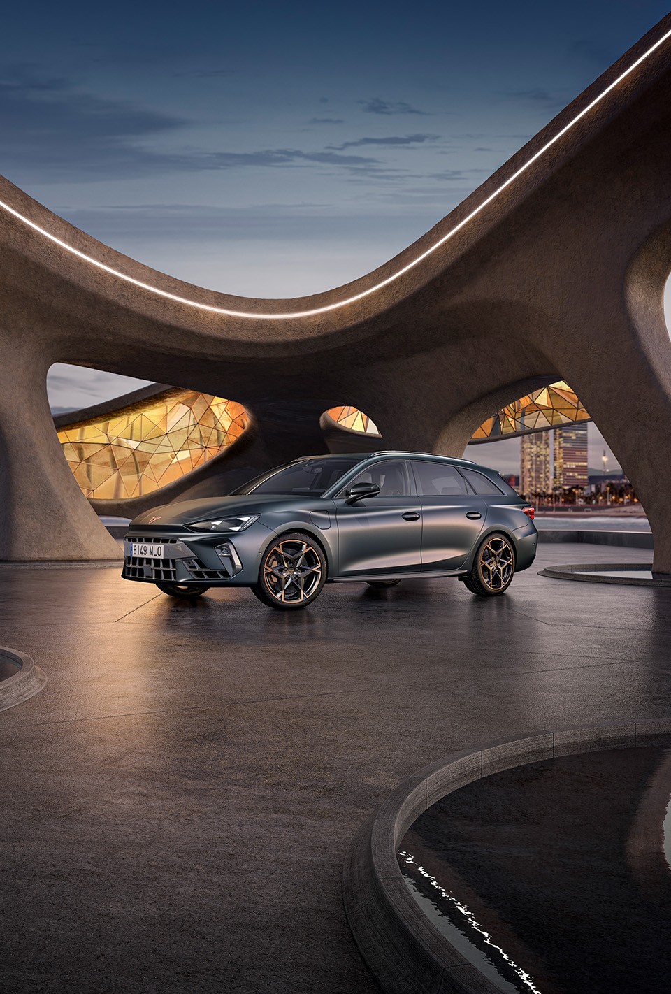 three quarter front view of new cupra Leon 2024 in Enceladus grey and architectural structure, parked on smooth cement, backdrop of Barcelona cityscape.